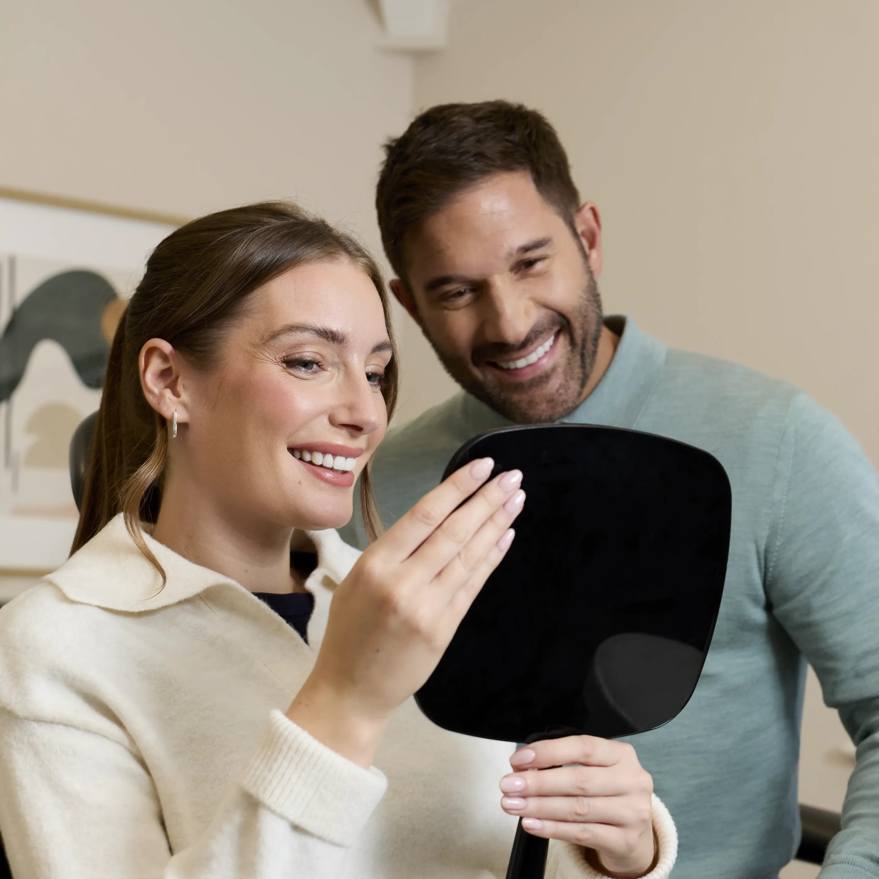 IU porcelain veneers patient being shown the result in a mirror